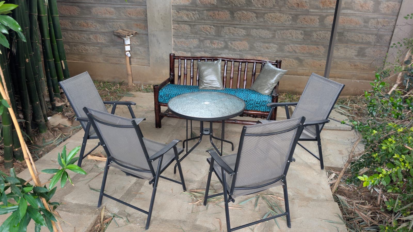 A bamboo bench and cushions in the garden at Shali Hotel